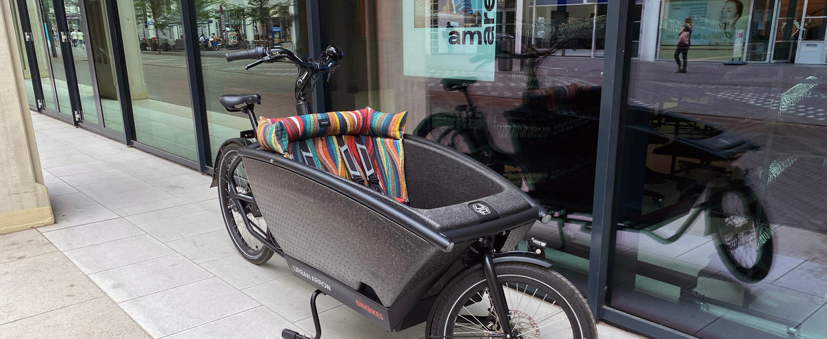 Kleurrijk gestreept bakfietskussen van eiapopeia in een Urban Arrow bakfiets.